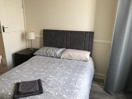 a bedroom with a bed with a gray headboard and a bed sidx sidx sidx at Ac Lounge 36 Room A in Rochford