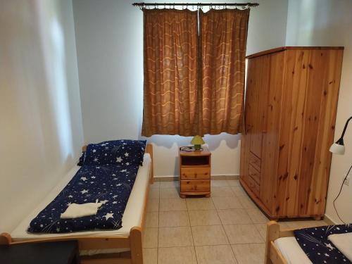 Cette petite chambre comprend un lit et une armoire en bois. dans l'établissement Tomaj Vendégház, à Tomajmonostora