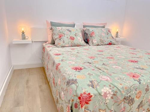a bedroom with a bed with a floral comforter at La Casa de Las Rosas in Costa de Antigua