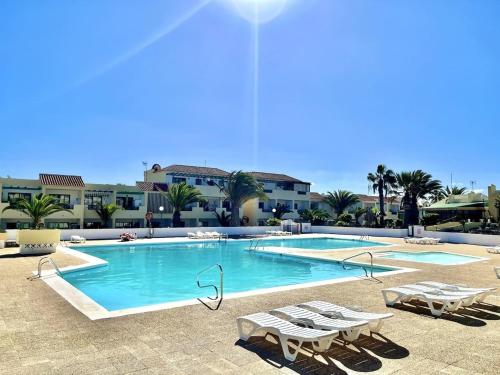 a swimming pool with lounge chairs in a resort at La Casa de Las Rosas in Costa de Antigua