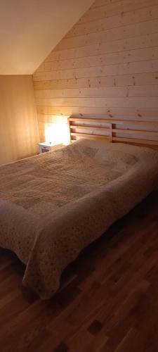 a bed in a room with a wooden floor at Les roses d'Olga in Aubechies