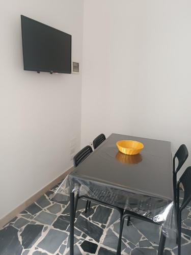 a dining room table with chairs and a flat screen tv at Cuore di Aci - Casa degli Zelanti in Acireale