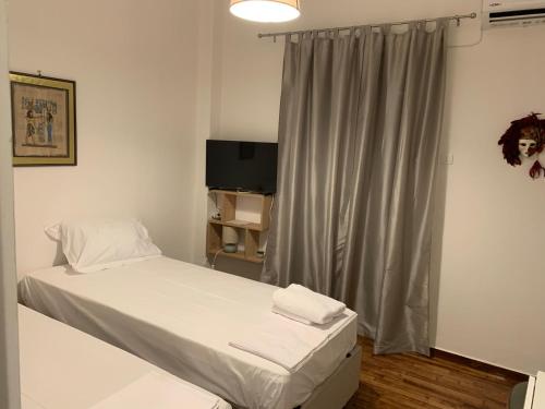 a small bedroom with a bed and a television at ALEX house in Athens
