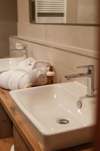 a bathroom with a white sink and a mirror at Hotel-Restaurant Kreuzberghof Tagungs- und Veranstaltungshotel in Tiefenbach
