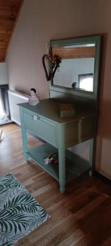 a blue dressing table with a mirror on it at Les roses d'Olga in Aubechies