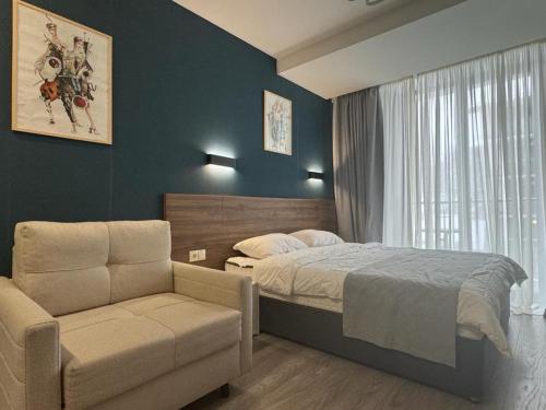 a bedroom with a bed and a chair and a window at Crystal New Resort in Bakuriani