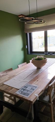 a wooden table with a bowl on top of it at Les roses d'Olga in Aubechies