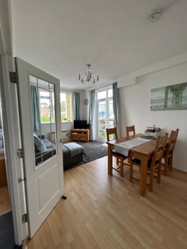 a living room with a dining room table and a bedroom at SHOREBANKS - Harbour View Apartment in Sandbanks. in Sandbanks