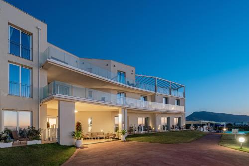 an exterior view of a building at dusk at Bellevue Sardinia Resort Affiliated by Meliá in Valledoria