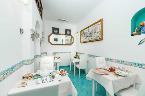 a dining room with white tables and white chairs at Albergo S. Andrea in Amalfi