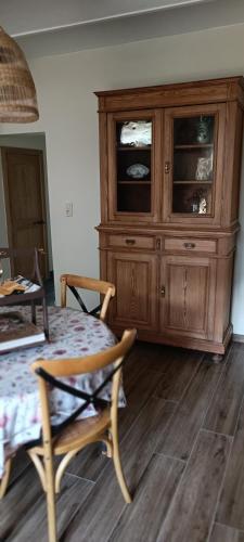 a wooden cabinet in a room with a table and chairs at Les roses d'Olga in Aubechies