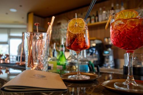 three cocktails sitting on top of a bar at Hotel Argentina in Grado