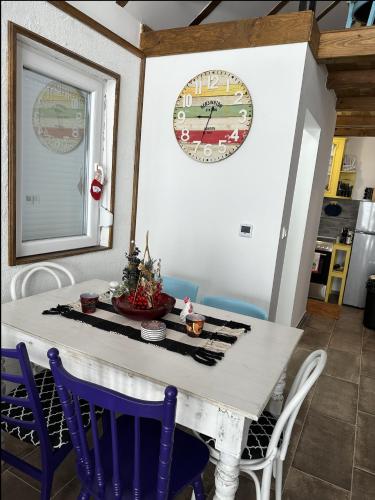Una mesa de comedor con sillas y un reloj en la pared. en Planinski beg, Tara, Sekulići, en Sekulić 