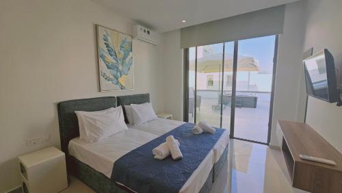a bedroom with a bed with two towels on it at STAY Oasis Luxury Villas in Ayia Napa