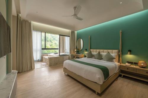 una camera da letto con un letto grande con una parete blu di Kananwas Resort, Kumbhalgarh a Kumbhalgarh
