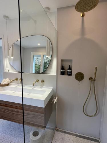 une salle de bain avec un lavabo et un miroir dans l'établissement Maison familiale, belle et moderne proche de Versailles et Thoiry, à Maule