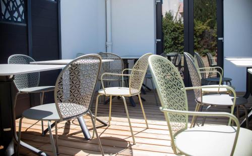 a row of chairs and tables on a patio at Hotel du Parc Euromédecine by AKENA in Montpellier