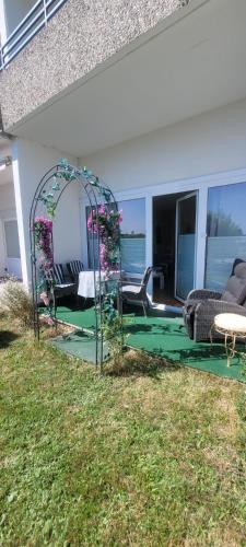 a patio with an arbor with flowers in the grass at Maria Altreichenau in Neureichenau