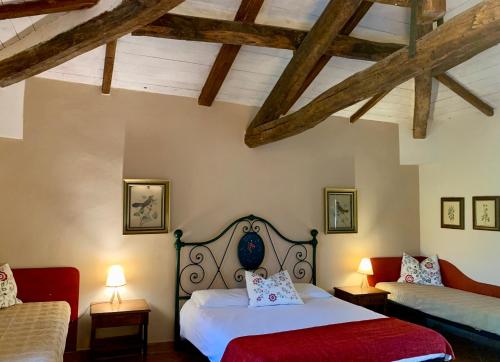 a bedroom with two beds and a couch at Agriturismo Fattoria La Prugnola in Montescudaio