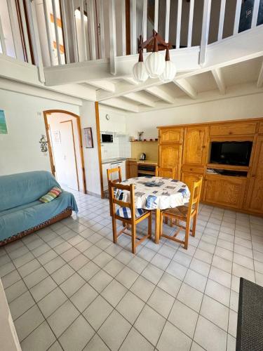 une cuisine avec une table et des chaises dans une pièce dans l'établissement Les aigrettes, à Saint-Pierre-dʼOléron