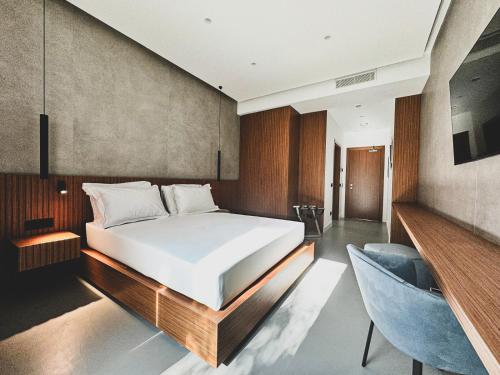 a bedroom with a bed and a blue chair at J Maluni City Hotel in Rome