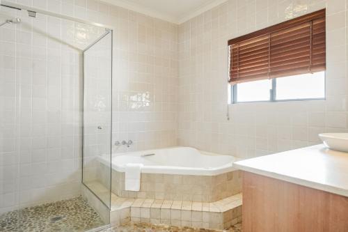 バイロンベイにあるByron Bay Beachfront Holiday Apartment - Pool, Ocean Views, 3 Bedrooms, Family & Group Accommodationのシャワー、浴槽、洗面台を備えたバスルーム