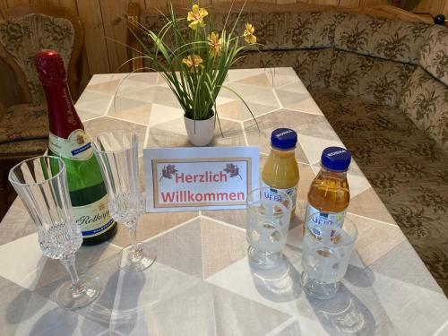 a table with bottles and glasses and a vase with flowers at Ferienhaus Klein in Winsen Aller