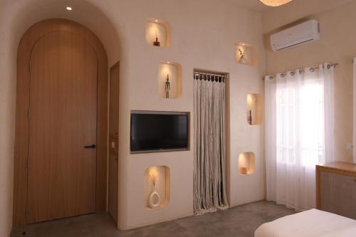a bedroom with a door with a television on the wall at Neoli in Jbeil