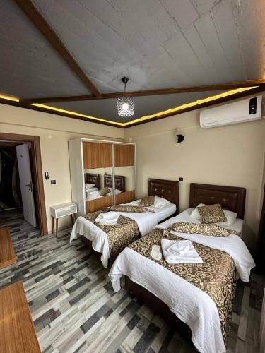 a bedroom with three beds in a room at Bayrak Suit Home Trabzon in Pelitli