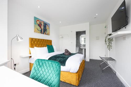a bedroom with a large bed and a tv at The Kent- Luxury Rooms in Manchester