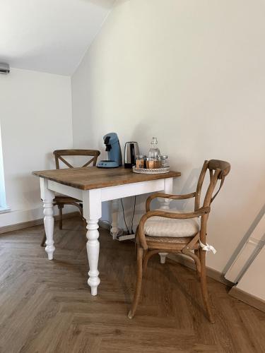 a table with two chairs and a coffee maker on it at Habitat in Momignies