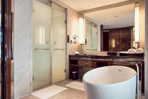 a bathroom with a tub and a large mirror at Minyoun Chengdu Dongda Hotel in Chengdu