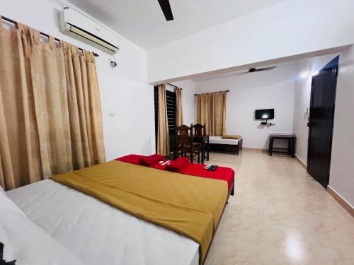 a bedroom with a bed and a living room at Hotel Sunday - Townhouse Club Airport Trivandrum in Trivandrum