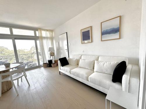 a white living room with a white couch and a table at Aptments4 - real estate solutions in Olbia