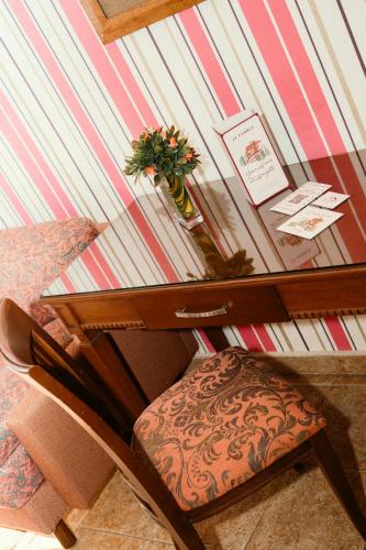 a glass table with a chair in front of a wall at Le Cedrus Hotel in Al Arz