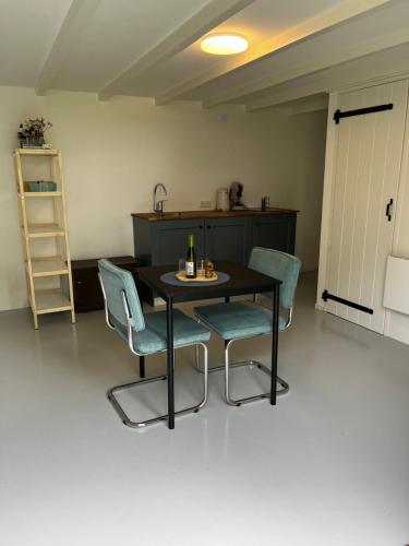 a table and chairs in a room with a kitchen at Meekhofsveen in Appelscha
