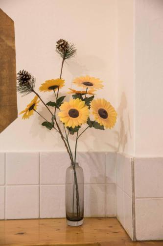 a vase filled with yellow flowers sitting on a table at Tempi Hotel in Athens