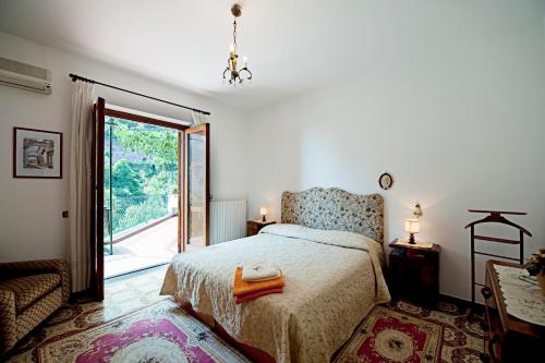 a bedroom with a bed and a large window at Villa Punta del Sole in Positano