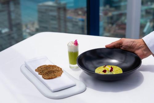 a bowl of food on a table with a plate of food at Hotel Madeira Centro in Benidorm
