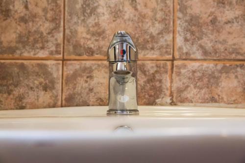 a silver faucet sitting on top of a sink at Tempi Hotel in Athens