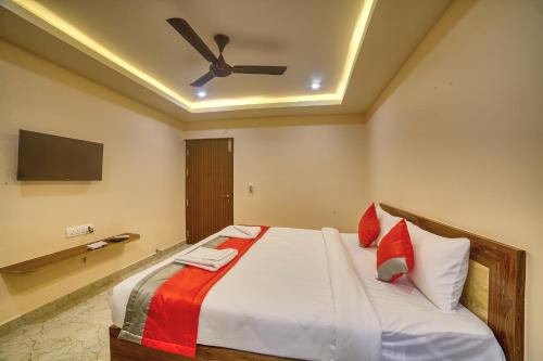 a bedroom with a bed with a ceiling fan at Stay On The Way Transit Hotel in Bengaluru