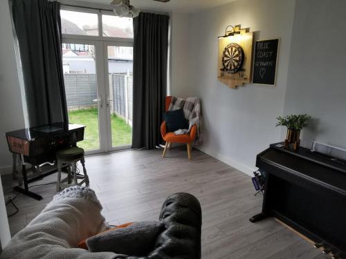 a living room with a couch and a piano at The Lookout, Seaside Getaway in Cleveleys