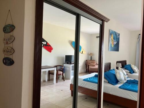a bedroom with a bed and a mirror at Agualina Kite Hotel Oceanfront Apartments in Cabarete