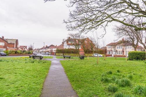 a path through a park with benches in the grass at The Lookout, Seaside Getaway in Cleveleys