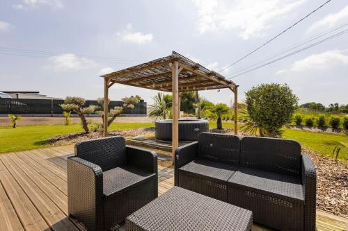 a patio with two chairs and a wooden deck at Maison à 5 minutes des plages in Lantic