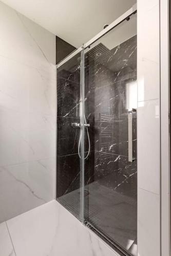 a shower with a glass door in a bathroom at Maison à 5 minutes des plages in Lantic
