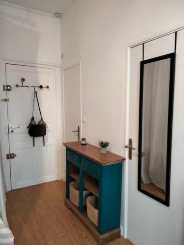 La salle de bains est pourvue d'une table bleue et d'un miroir. dans l'établissement LE SAINT LOUIS - Hypercentre - Opéra - Proche Parcs, à Vichy