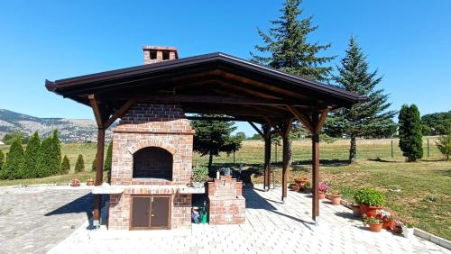 a brick pizza oven with a wooden roof at Apartman Zdenka 2 in Livno