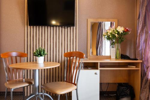 a table and two chairs in a room with a mirror at Hotel Brod - Free Parking in Sofia