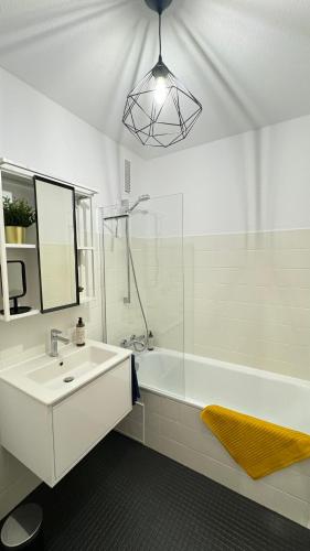 a bathroom with a sink and a shower and a mirror at Sonniges City-Apartment mit Südbalkon und Parklatz in Neusäß